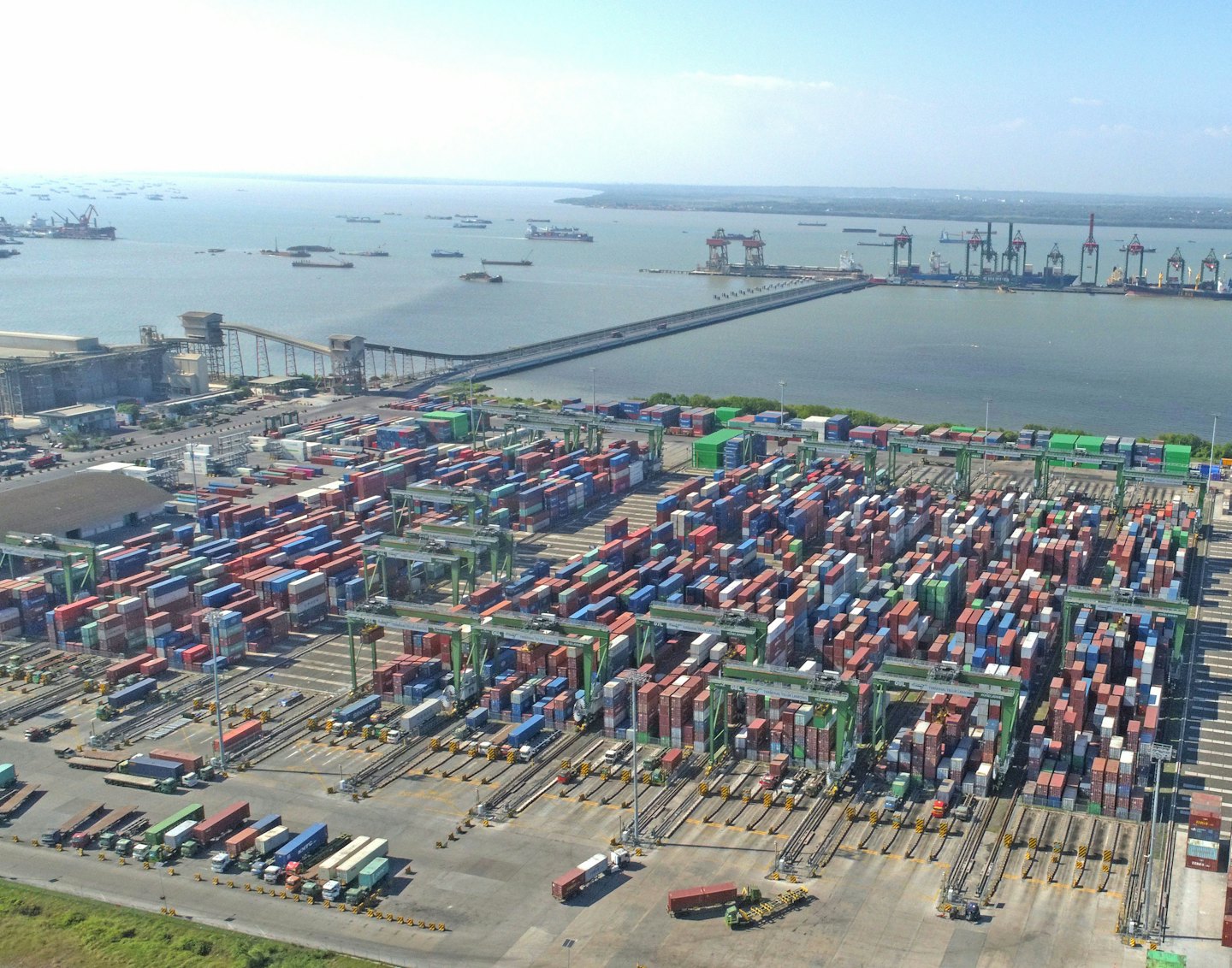 Aerial view of a busy container port with cranes and ships.