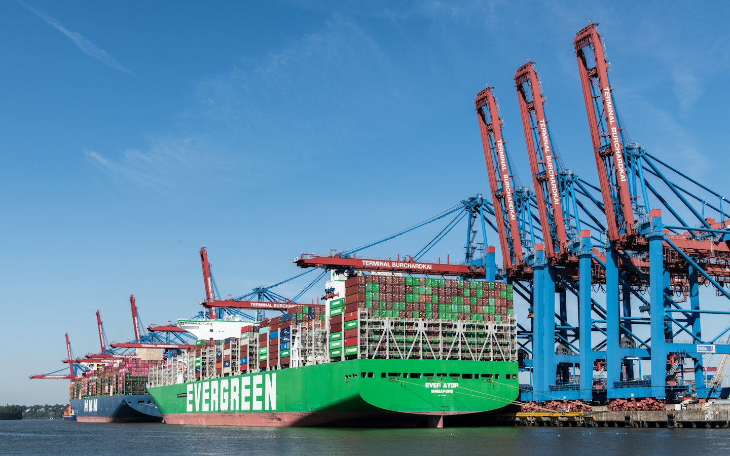 Two large container ships docked at a busy cargo port.